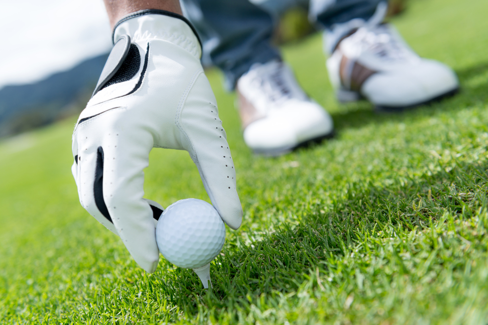 Man placing golf ball at the tee box